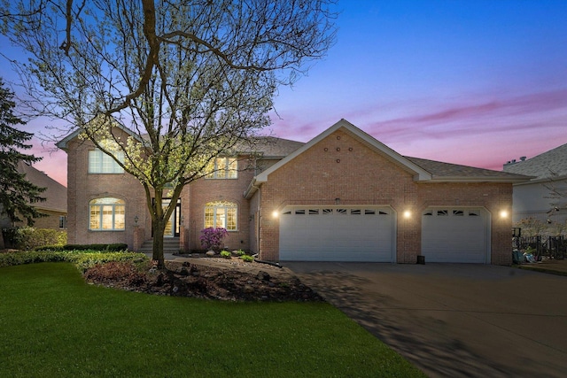 traditional-style house with brick siding, a front lawn, concrete driveway, and an attached garage