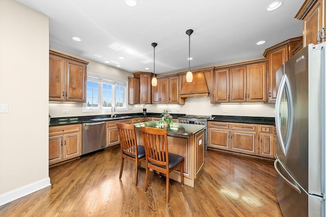 kitchen featuring a sink, brown cabinetry, custom exhaust hood, a center island, and appliances with stainless steel finishes