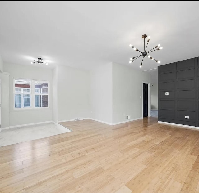 11414 S Wallace St, Chicago, IL 60628 - unfurnished living room with a chandelier, light wood-style flooring, and baseboards