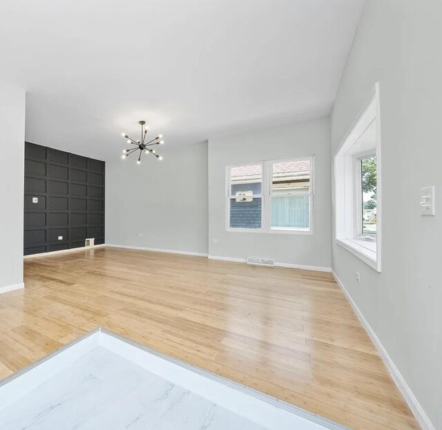 11414 S Wallace St, Chicago, IL 60628 - empty room with a chandelier, wood finished floors, and baseboards