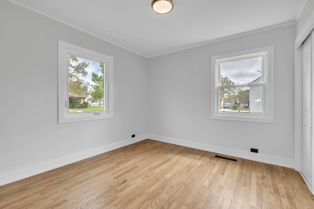 unfurnished room with crown molding, baseboards, visible vents, and light wood-type flooring