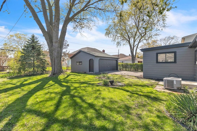 view of yard featuring an outbuilding, a detached garage, and cooling unit