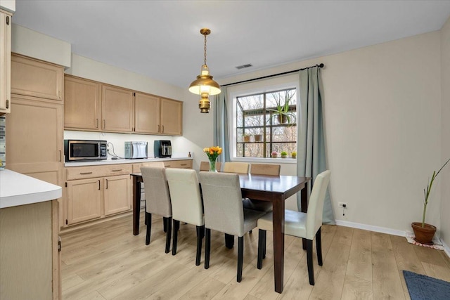 dining space with visible vents, baseboards, and light wood-type flooring