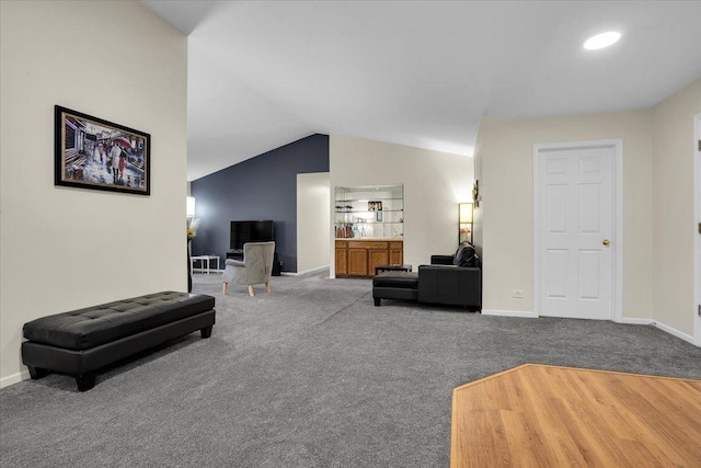 carpeted living room featuring lofted ceiling and baseboards