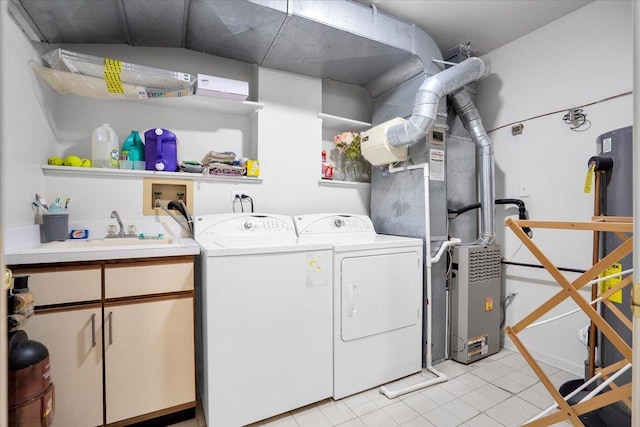 washroom featuring light tile patterned floors, a sink, cabinet space, and washer and clothes dryer