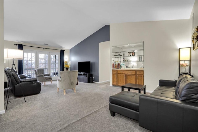 living room featuring lofted ceiling, visible vents, baseboards, and light carpet