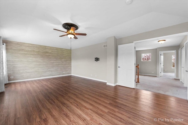 unfurnished room featuring a ceiling fan, baseboards, visible vents, and wood finished floors