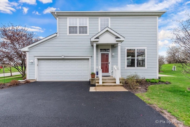 traditional home with driveway, a front yard, and a garage