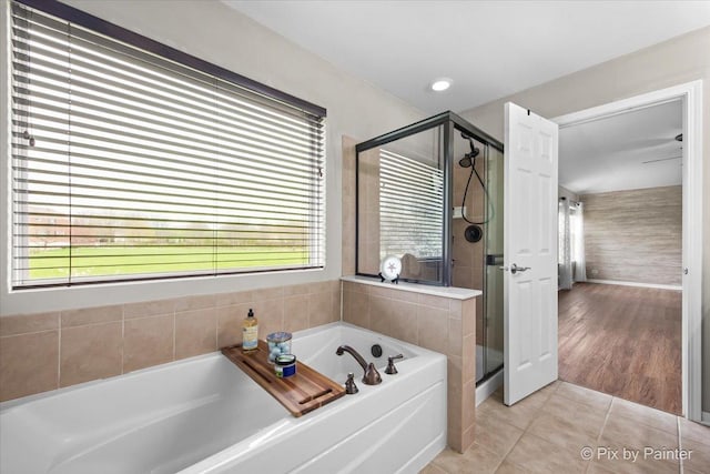 bathroom featuring a healthy amount of sunlight, tile patterned flooring, a garden tub, and a stall shower