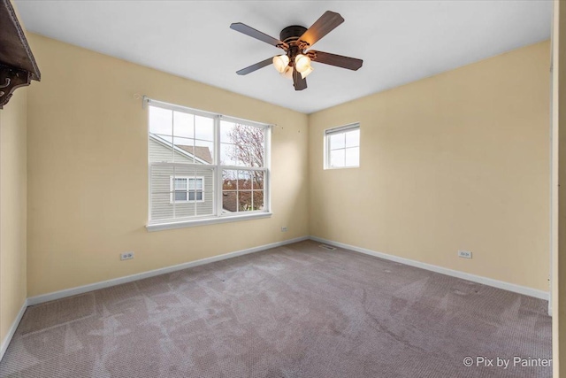 spare room featuring carpet floors, baseboards, and ceiling fan