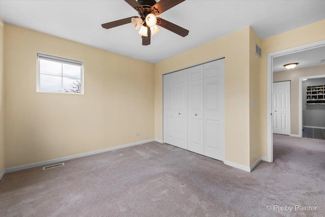 unfurnished bedroom featuring baseboards, carpet flooring, and visible vents