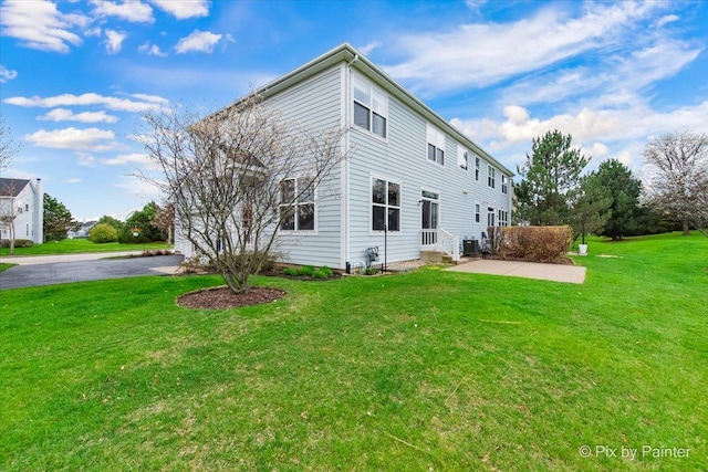 view of side of home featuring a lawn and cooling unit