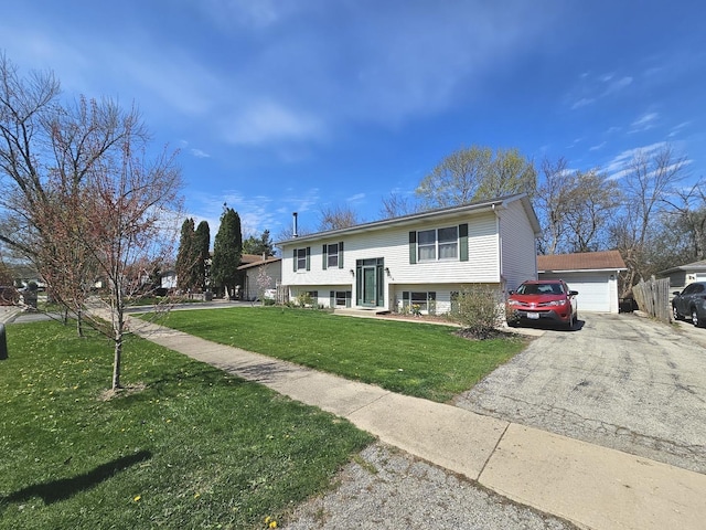 bi-level home with a detached garage and a front lawn