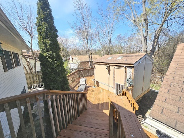 wooden deck with fence, a storage unit, and an outdoor structure