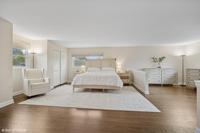 bedroom with baseboards and dark wood-style floors
