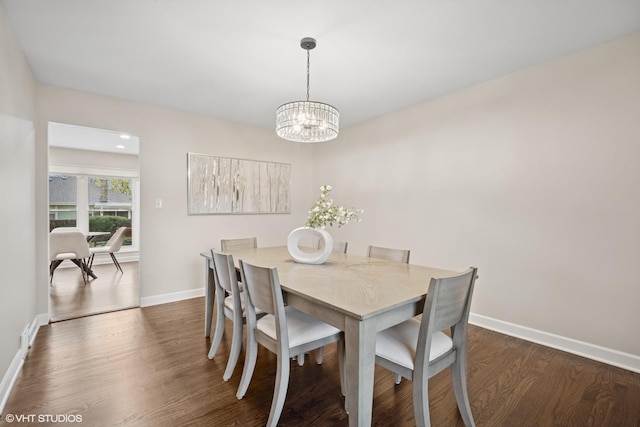 dining area featuring baseboards, dark wood finished floors, and a chandelier