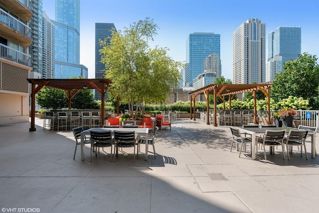 view of community with a patio area, a city view, outdoor dry bar, and a pergola
