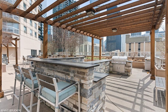 view of patio / terrace featuring exterior kitchen, a pergola, a city view, outdoor wet bar, and a grill