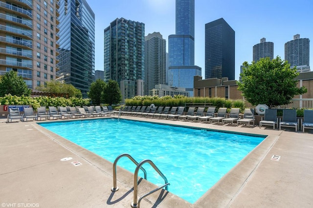 community pool with a city view and a patio