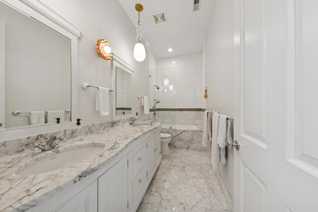 2215 N Lakewood Ave, Chicago, IL 60614 - bathroom featuring a tub with marble appearance, double vanity, marble finish floor, a sink, and visible vents