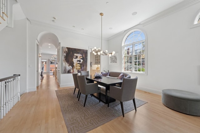 2215 N Lakewood Ave, Chicago, IL 60614 - dining area featuring arched walkways, an inviting chandelier, baseboards, light wood-type flooring, and crown molding