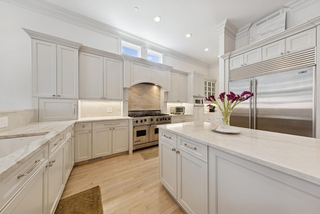 2215 N Lakewood Ave, Chicago, IL 60614 - kitchen with light stone counters, tasteful backsplash, crown molding, built in appliances, and recessed lighting