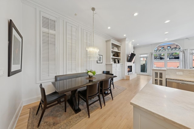 2215 N Lakewood Ave, Chicago, IL 60614 - dining area with light wood-type flooring, recessed lighting, a lit fireplace, and baseboards