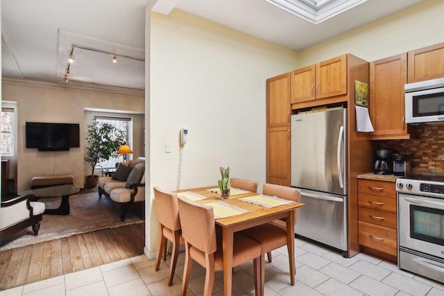 1400 N La Salle St Unit 3N, Chicago, IL 60610 - kitchen featuring appliances with stainless steel finishes, light tile patterned flooring, open floor plan, backsplash, and track lighting