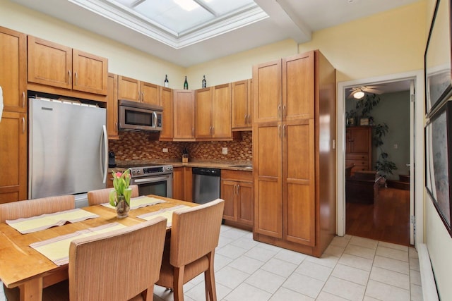 1400 N La Salle St Unit 3N, Chicago, IL 60610 - kitchen featuring stainless steel appliances, decorative backsplash, light tile patterned floors, brown cabinets, and a sink