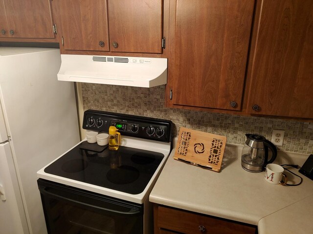 kitchen with decorative backsplash, brown cabinetry, electric range, under cabinet range hood, and light countertops