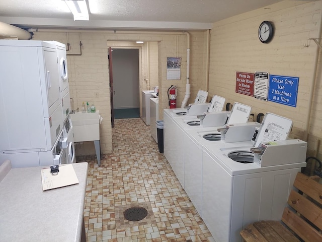 common laundry area with a sink, stacked washer and clothes dryer, light floors, and independent washer and dryer