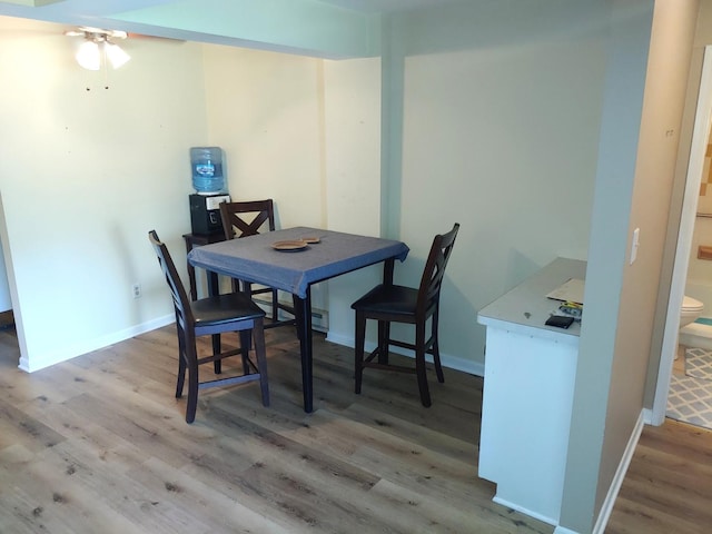 dining room with ceiling fan, light wood finished floors, and baseboards