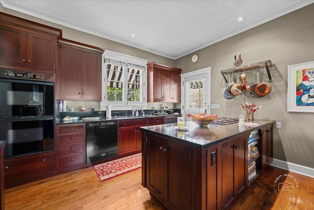 kitchen with black appliances, dark countertops, light wood-style floors, a sink, and crown molding