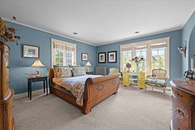 bedroom with light carpet, ornamental molding, baseboards, and radiator