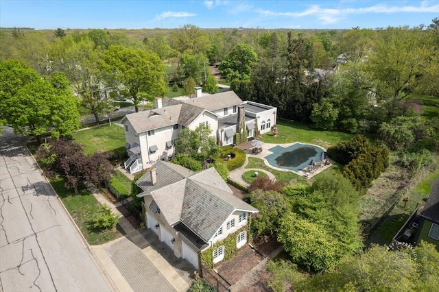 view from above of property featuring a heavily wooded area and a pool area