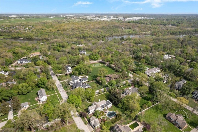 aerial view of property's location featuring a heavily wooded area and a nearby body of water