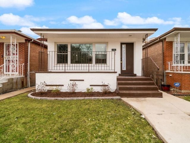 519 E 91st St, Chicago, IL 60619 - view of front of home with a porch, a front yard, and brick siding