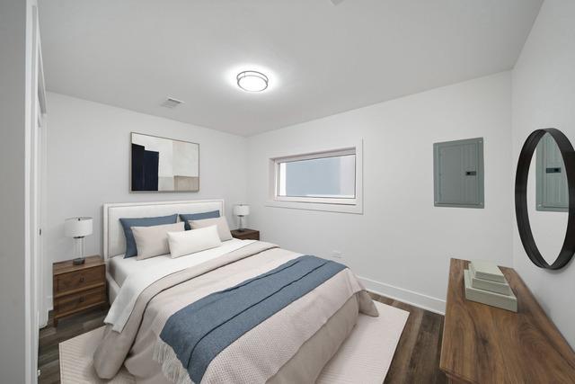 519 E 91st St, Chicago, IL 60619 - bedroom featuring electric panel, baseboards, wood finished floors, and visible vents