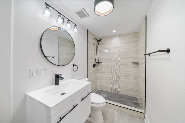 519 E 91st St, Chicago, IL 60619 - full bath featuring visible vents, toilet, tile patterned floors, vanity, and tiled shower