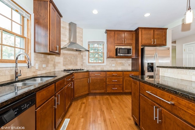 12521 S Harold Ave, Palos Heights, IL 60463 - kitchen featuring a sink, stainless steel appliances, wall chimney range hood, dark stone countertops, and light wood-type flooring