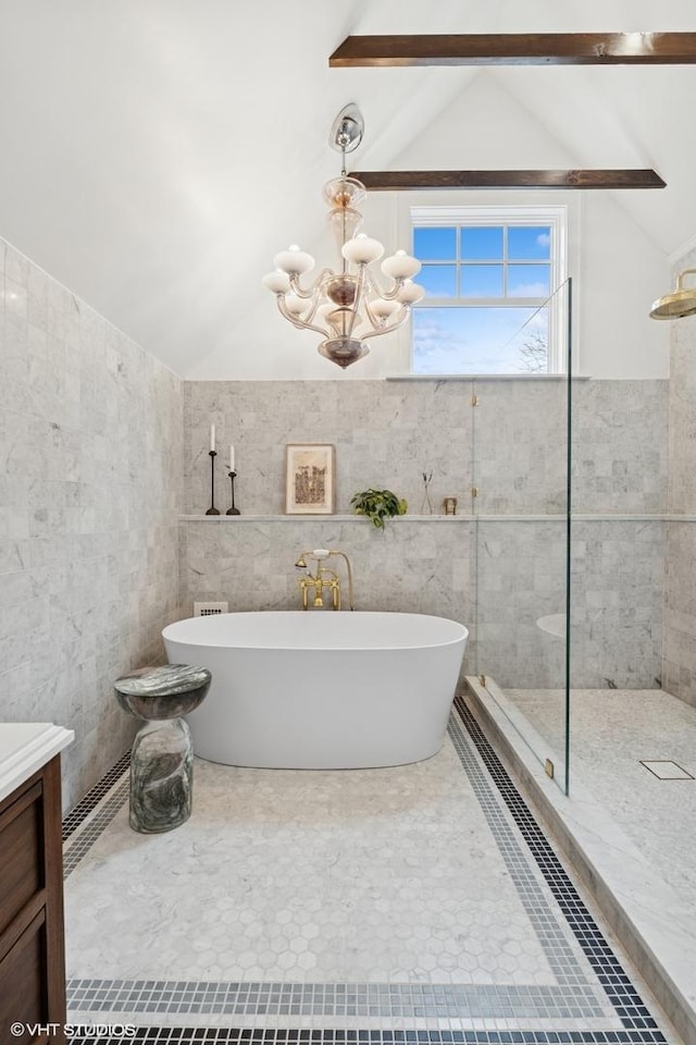 bathroom featuring tiled shower, a chandelier, vaulted ceiling, tile walls, and a soaking tub