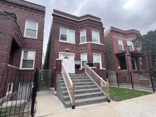 townhome / multi-family property featuring brick siding, fence private yard, and a gate