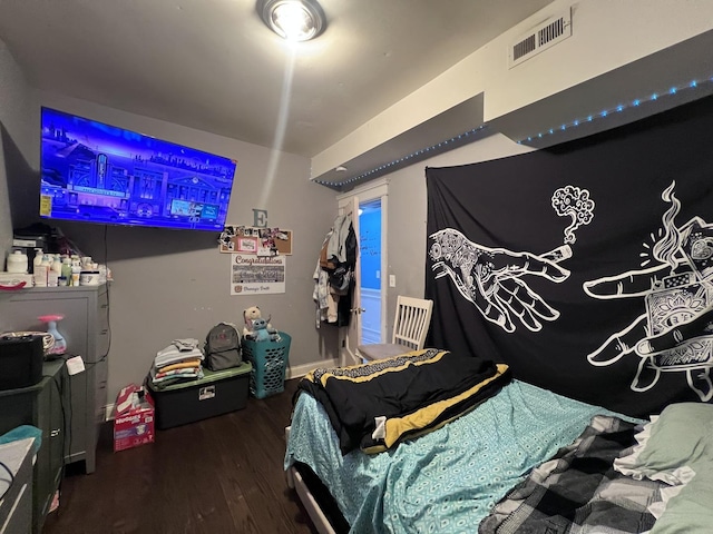 bedroom featuring visible vents and wood finished floors