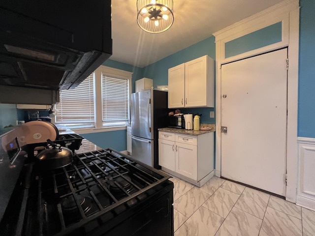 kitchen with ventilation hood, white cabinets, freestanding refrigerator, black gas range, and marble finish floor