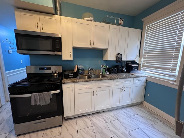 kitchen featuring a sink, marble finish floor, appliances with stainless steel finishes, and white cabinets