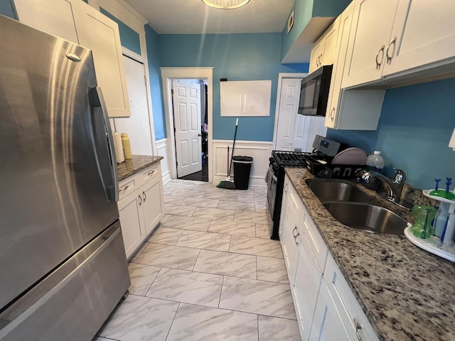 kitchen with visible vents, a sink, a wainscoted wall, marble finish floor, and stainless steel appliances
