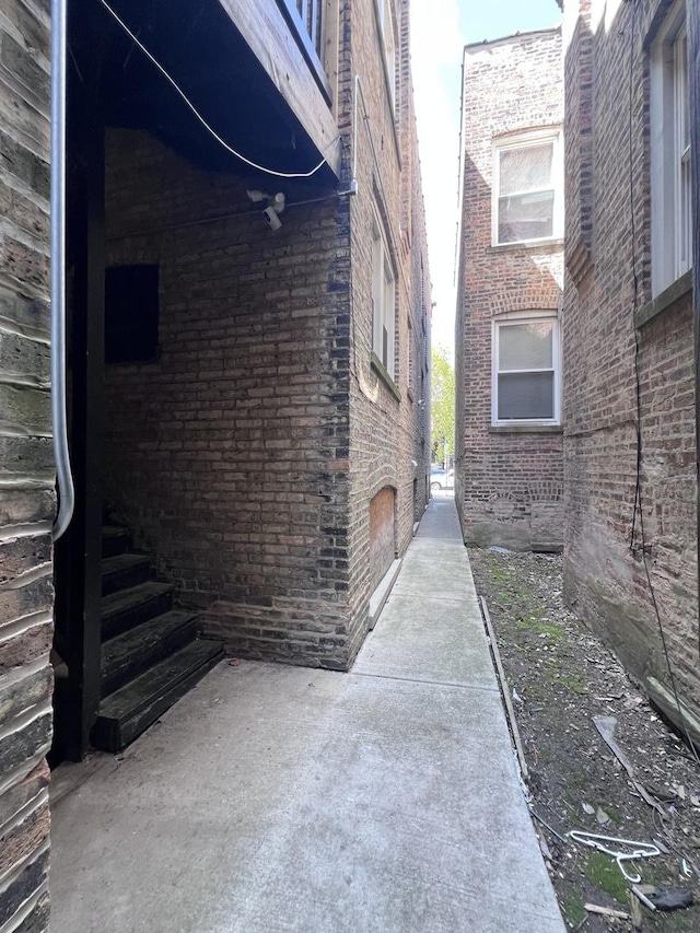 view of side of home featuring brick siding and a patio