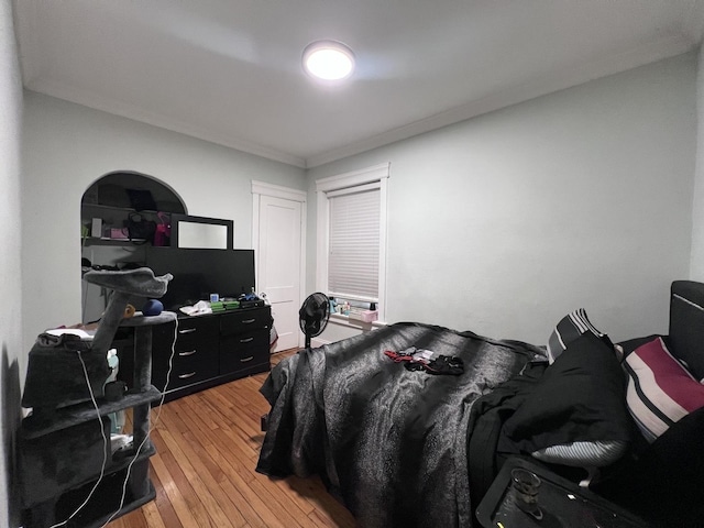 bedroom featuring ornamental molding and light wood-style floors