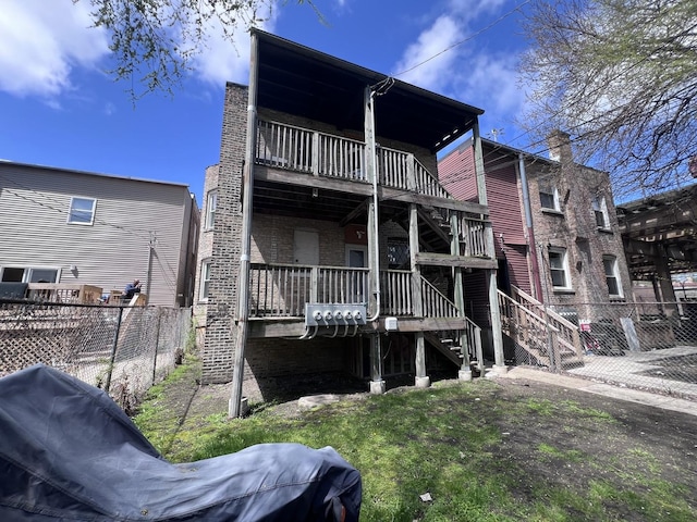 back of property with fence and stairway