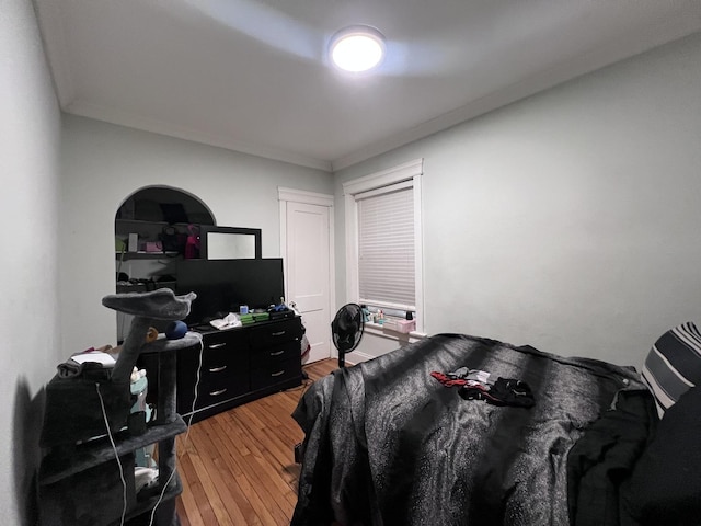 bedroom with light wood-style floors and ornamental molding